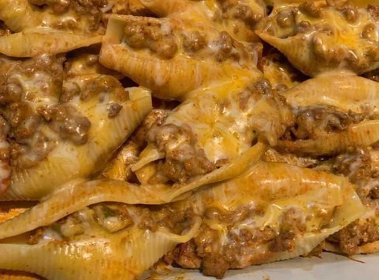 Ingredients ( 4 servings ) 8 jumbo pasta shells ½ pound ground beef ½ (1.25 ounce) package taco seasoning mix ½ cup water ½ (16 ounce) can refried beans ⅓ cup shredded Cheddar cheese ½ (16 ounce) jar salsa, divided 2 tablespoons sliced green onion 2 tablespoons shredded Cheddar cheese ¼ cup sour cream